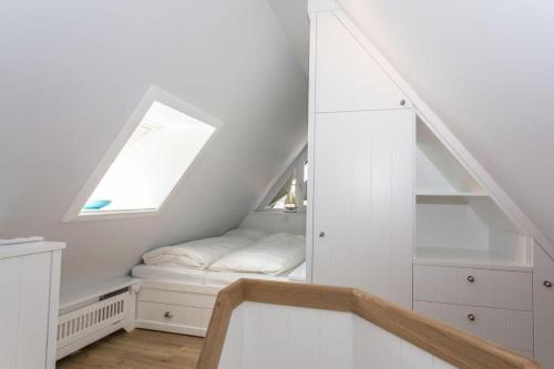 Dieses weiße Zimmer verfügt über ein Fenster und eine Treppe. in der Unterkunft Haus Norderstrasse 61 Whg 9 in Westerland
