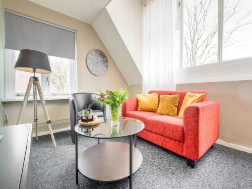 uma sala de estar com um sofá vermelho e uma mesa em Cozy Holiday Home in Elim with a Furnished Garden em Elim