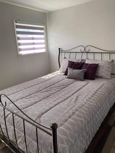 una camera da letto con un grande letto con cuscini viola di Maison Carofanne a Saint-Siméon