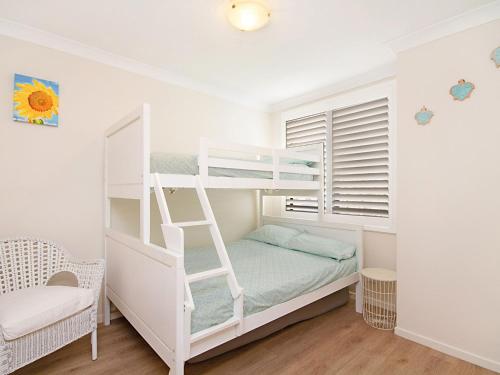 een wit stapelbed met een ladder in een kamer bij Kirra Vista Apartments Unit 18 in Gold Coast