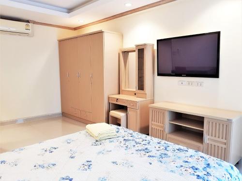 a bedroom with a bed and a flat screen tv at Sea view apartment Jomtien beach condominium 12th Floor in Jomtien Beach