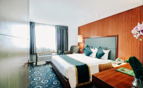 En eller flere senge i et værelse på Greenhills Elan Hotel Modern