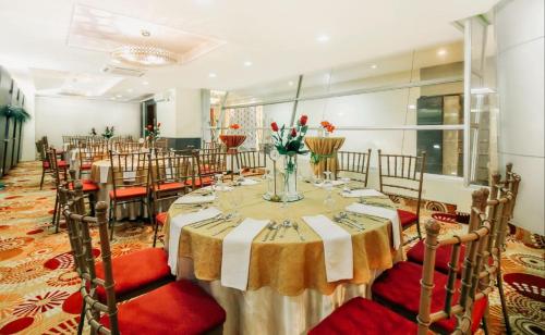 a banquet hall with a long table with red chairs at Greenhills Elan Hotel Modern - Newly Renovated in Manila