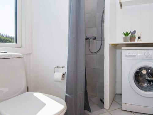 a bathroom with a toilet and a washing machine at 6 person holiday home in Ringkøbing-By Traum in Søndervig