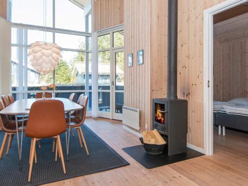 a living room with a table and a fireplace at Three-Bedroom Holiday home in Ulfborg 23 in Fjand Gårde