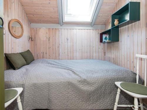 スナーヴィグにあるThree-Bedroom Holiday home in Ringkøbing 26のベッドルーム1室(ベッド1台、テーブル2台、窓付)