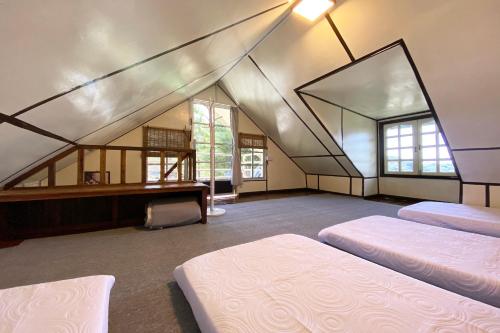 um quarto amplo com 2 camas e uma janela em OYO Homes 90264 Lily Cottage & Kitchen em Ranau