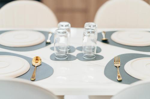 a table with white plates and gold forks and spoons at Poonsiri Varich Pool Villa Aonang in Ao Nang Beach