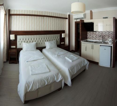 イスタンブールにあるNew Houseのベッド2台とキッチンが備わるホテルルームです。
