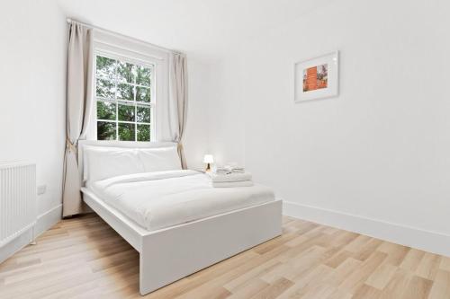 Een bed of bedden in een kamer bij Airy Spacious 1 Bedroom Aprtment with Garden in Brixton