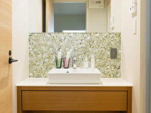 a bathroom with a sink and a mirror at Nagi Kurashiki Hotel&Lounge in Kurashiki