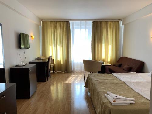 una camera d'albergo con letto, sedia e scrivania di Casa Ruxandrei a Constanţa