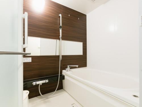 a bathroom with a shower with a wooden wall at Nagi Kurashiki Hotel&Lounge in Kurashiki