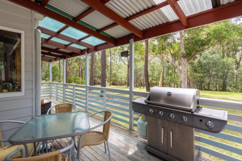 a screened porch with a grill and a table at Bay and Bush Jervis Bay in Huskisson