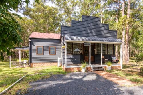 a small house with a black roof at Bay and Bush Jervis Bay in Huskisson