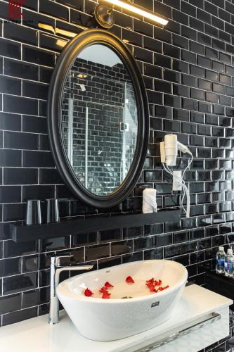 a bathroom with a large mirror and a bath tub at TTR Skypool View Hotel in Da Lat