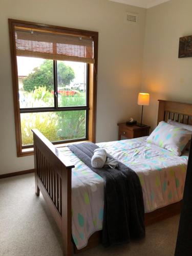 ein Schlafzimmer mit einem Bett und einem großen Fenster in der Unterkunft The Red Door in Mount Gambier