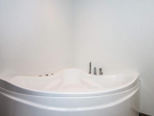 8 person holiday home in Ansager في Ansager: حوض استحمام في الحمام بجدار أبيض