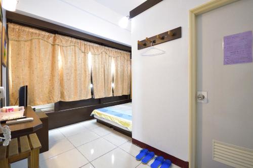 a room with a bed and a desk and a door at Luyi Ludao B&B in Green Island