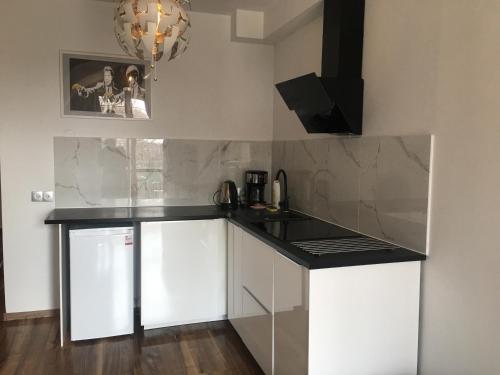 a kitchen with white cabinets and a black counter top at Kamienica Nadmorska in Jastarnia