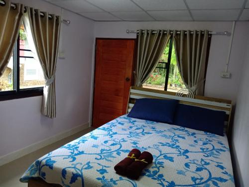 - une chambre dotée d'un lit avec deux chaussures brunes dans l'établissement เฮือนน้ำน่าน house by the river nan, à Uttaradit