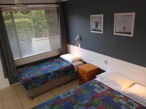 a bedroom with two twin beds and a window at Aspley Sunset Motel in Brisbane