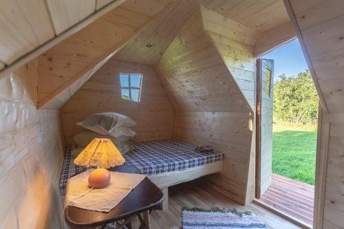 ein Zimmer in einem winzigen Haus mit einem Bett und einem Tisch in der Unterkunft külalistemaja Kadrina mõisa kämpingud in Kadrina