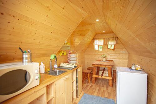 una cocina con microondas y fregadero en una cabaña en külalistemaja Kadrina mõisa kämpingud, en Kadrina