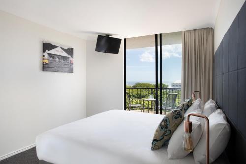 a hotel room with a bed and a balcony at Mantra Esplanade in Cairns