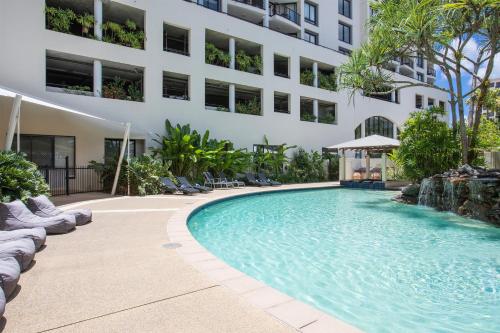 a swimming pool in front of a building at Mantra Esplanade in Cairns