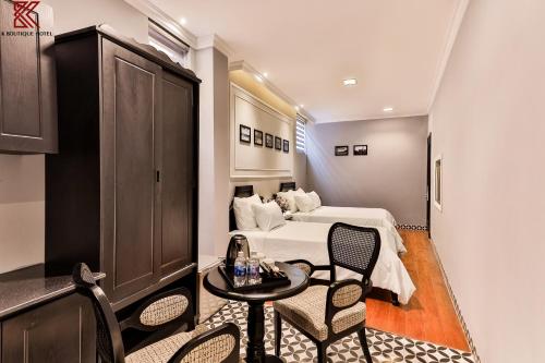 a room with a bed and a table and chairs at TTR Skypool View Hotel in Da Lat