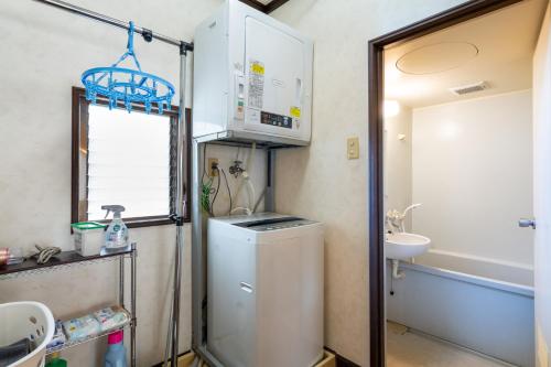 a small bathroom with a washer and a sink at Type B Room 63平米 -ウル エスポワール石垣- in Ishigaki Island