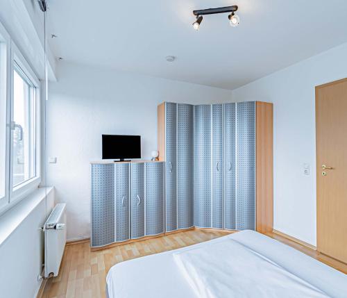 a bedroom with a bed and a tv on a wall at Hotel Tannenblick in Bad Vilbel