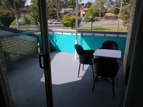 a balcony with two chairs and a table on it at Aspley Sunset Motel in Brisbane