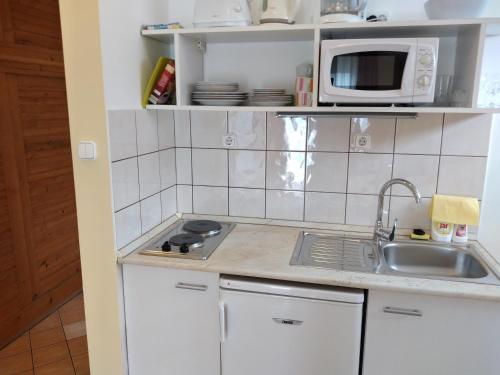 a kitchen with a sink and a microwave at Hévíz Erika Apartman in Hévíz