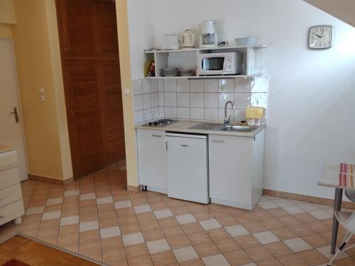 a small kitchen with a sink and a microwave at Hévíz Erika Apartman in Hévíz