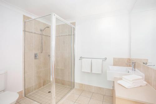 a bathroom with a shower and a sink at Mantra Aqueous on Port in Port Douglas