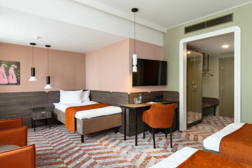 a hotel room with two beds and a desk at Kaunas in Kaunas