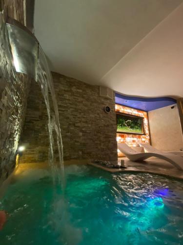 a swimming pool in a house with a waterfall at Aurelia Garden Gold B&B in Rome