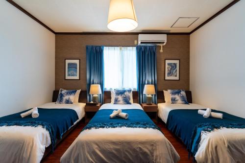 three beds in a room with blue and white at Type A Room 123平米 -ウル エスポワール石垣- in Ishigaki Island