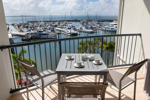 a table and chairs on a balcony with a marina at Mantra Hervey Bay in Hervey Bay