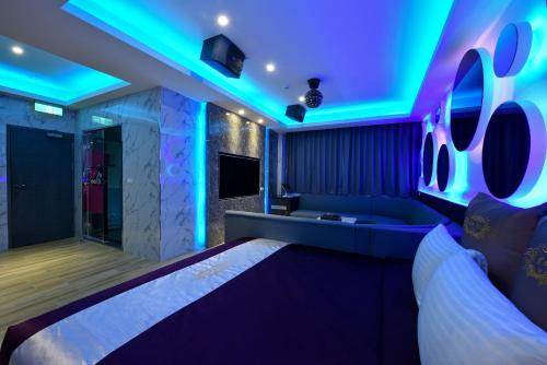 a room with a couch and blue lights at I-Like Motel in Pingzhen