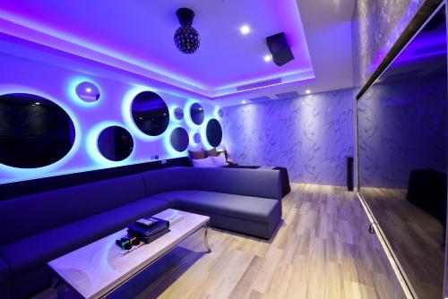 a purple living room with a couch and a table at I-Like Motel in Pingzhen