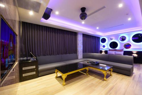 a living room with a couch and a tv at I-Like Motel in Pingzhen