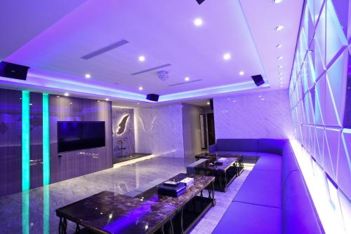 a living room with a purple couch and a tv at I-Like Motel in Pingzhen