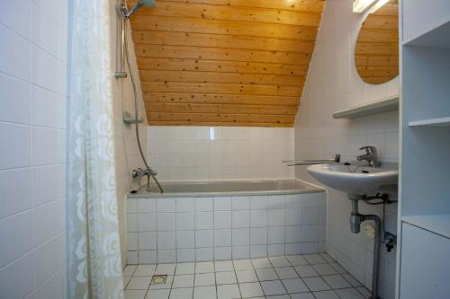 y baño con bañera y lavamanos. en Stijlvolle vakantiewoning just for holliday, en Gramsbergen