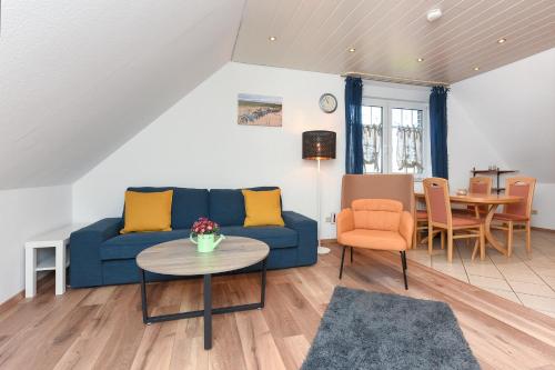 sala de estar con sofá azul y mesa en Ferienwohnung Wattgeflüster, en Esens