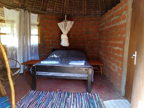 Mailua的住宿－Mailua Retreat，卧室配有砖墙内的床铺