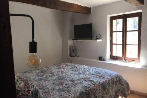 - une chambre avec un lit, une télévision et une fenêtre dans l'établissement Maison Drome provençale vue imprenable, à Plaisians
