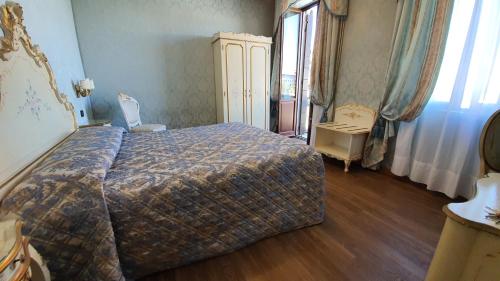 a bedroom with a bed and a dresser and a window at Hotel Carlton On The Grand Canal in Venice